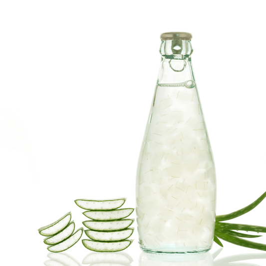 Bottle of Aloe Vera Juice with sliced Aloe Vera leaves next to it